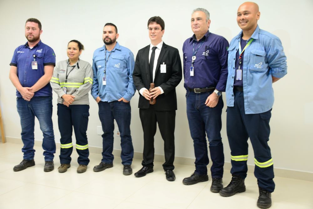 Imagem mostra um grupo de trabalhadores com o juiz do trabalho