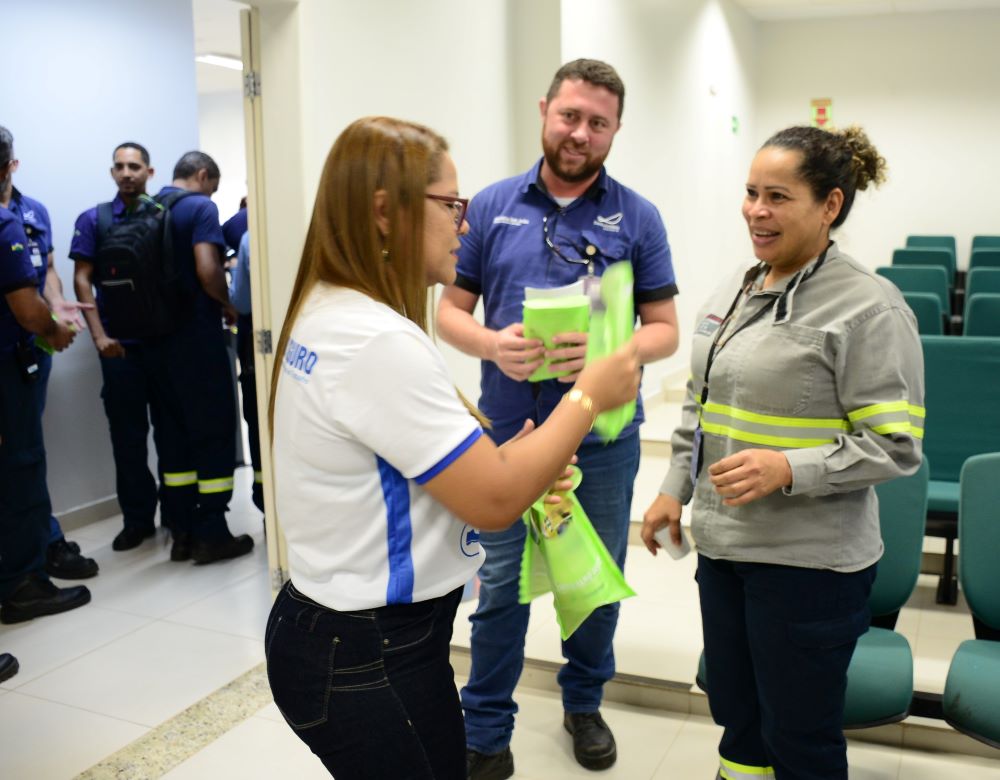 Imagem mostra trabalhadores recebendo kits de conscientização