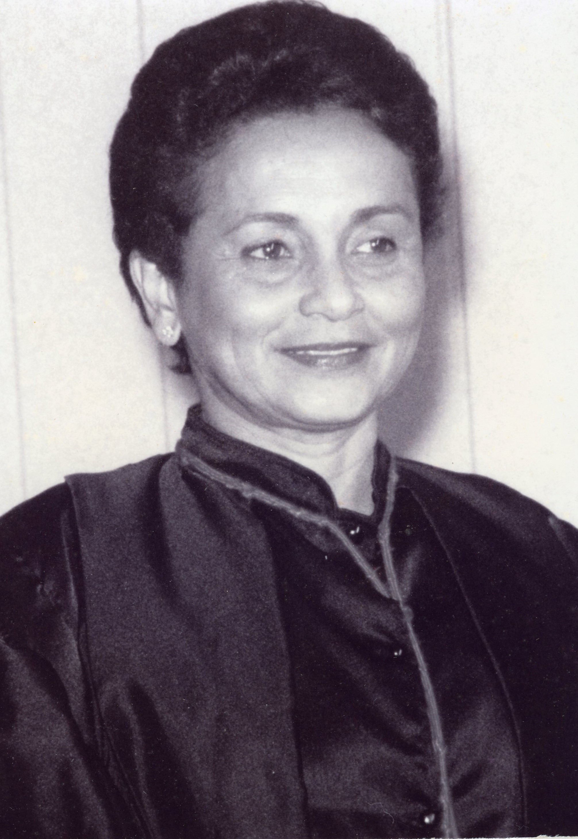 Fotografia em preto e branco, mulher parda, cabelos negros, curto, usando toga.