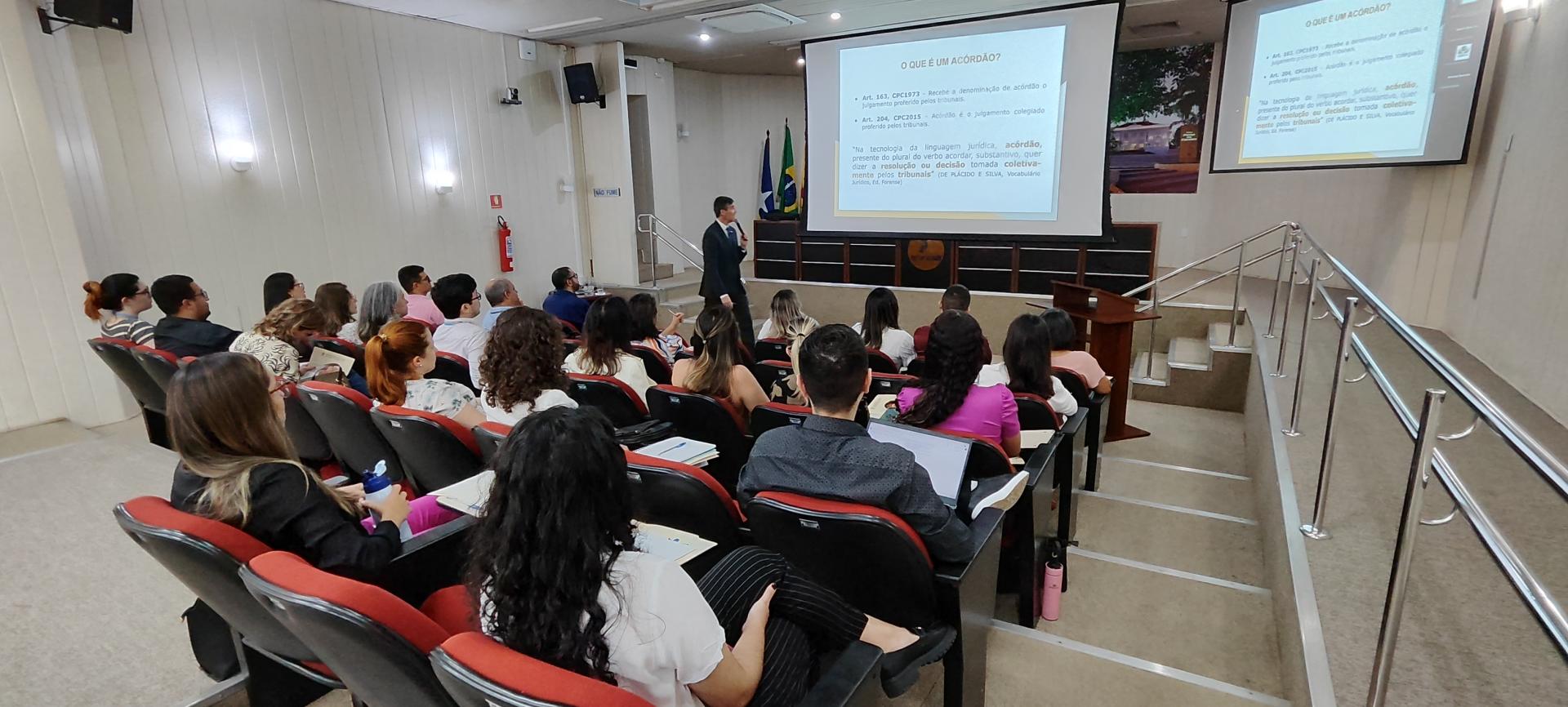 A foto mostra várias pessoas no auditório do TRT-14 