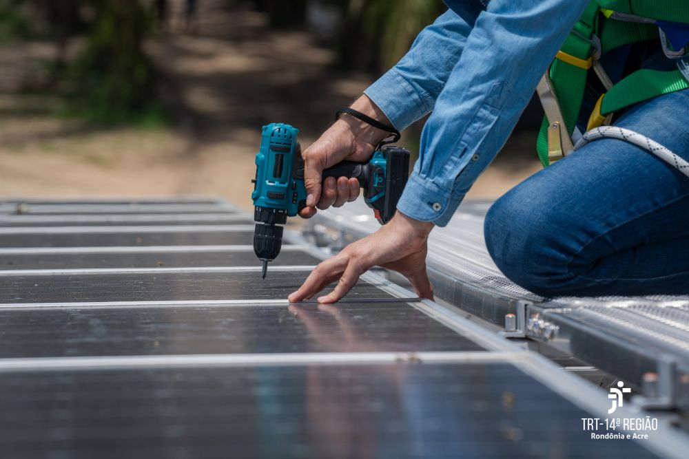 Energia solar, trabalhador instala painéis solares no telhado de um prédio..